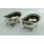 A pair of George IV silver open salts of rounded rectangular form with gadrooned rims raised on