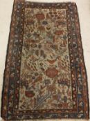 A Caucasian rug, the central panel set with stylised bird and foliate decoration on a grey ground,