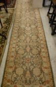 An Indian style runner, the central panel set with repeating floral decoration on a mushroom,