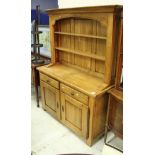 A modern oak dresser with two tier boarded plate rack over two drawers and two cupboard doors