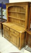 A modern oak dresser with two tier boarded plate rack over two drawers and two cupboard doors