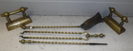 A set of three brass fire irons with fire dogs