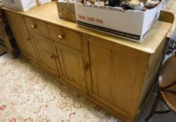 A circa 1900 pine dresser the plain top above two drawers above two cupboard doors flanked by two