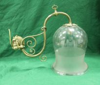A 19th Century brass scrollwork wall light with engraved starburst decorated and frosted bell