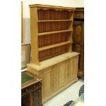 A modern pine dresser of three cupboard doors with an associated oak three tier plate rack