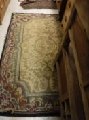 An Indian rug, the central panel set with acanthus decoration on a beige ground,