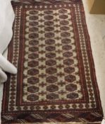 A Turkamen rug, the central panel set with repeating medallions on a cream ground within a cream,