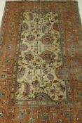 A Tabriz carpet, the central panel set with all-over floral decoration on a mushroom ground,