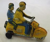 A Technofix (Western Germany) friction drive tinplate scooter with rider and woman passenger