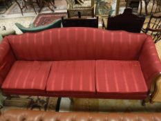 A Georgian style four seat sofa with red upholstery to carved cabriole legs