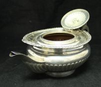 An Edwardian silver squat reeded teapot with gadrooned and foliate decorated rim (by Goldsmiths and