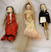 Two painted wooden peg dolls as a bride and groom and another in floral dress