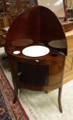 An early 19th Century mahogany washstand with rising back opening to reveal a bowl and dish over a