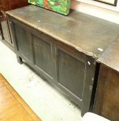 An 18th Century oak coffer with two planked top with molded edge above three plain panels on style