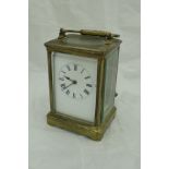 A circa 1900 lacquered brass cased carriage clock with white enamel dial and Roman numerals