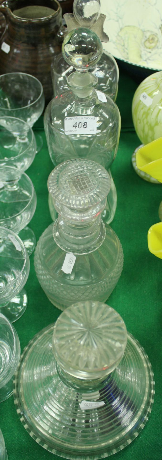 A 19th Century clear glass waisted decanter with plated rim, another waisted decanter,