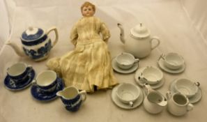 A circa 1900 biscuit fired porcelain headed doll in long white dress with cloth body together with