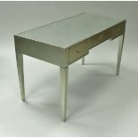 A modern silvered writing table, the mirrored top over three frieze drawers on square tapered legs,
