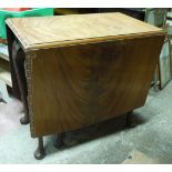A mahogany drop leaf dining table on cabriole legs with pad feet