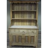 A Victorian pine dresser with flared cornice and shaped frieze planked double shelved back,