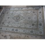 A good bordered rug worked with a central medallion and floral trails on a sand coloured ground,