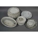 Sixteen plates with pierced rims, eleven floral moulded circular plates,