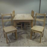 A reproduction pine kitchen table with four matching ladder back chairs,