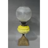 A Victorian oil lamp with acid etched globe chimney and yellow glass moulded reservoir on gold