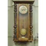 A late 19th century walnut cased Vienna wall clock with papered cream chapter ring,