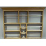 A Victorian pine dresser rack with flared cornice railed shelves and central recess with pair of