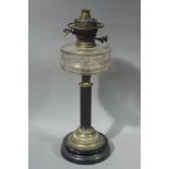 A Victorian black glass and gilt metal oil lamp having a clear glass reservoir