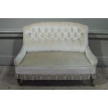 A Victorian salon sofa re-upholstered in buttoned beige dralon tasseled fringe,