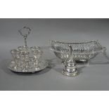 A silver plated egg cruet of five egg cups on a circular stand with pierced rim and ball feet,