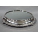 A mirrored silver plate cake stand circular outline with gadroon rim and on shell bracket feet, 37.