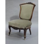 A Victorian mahogany framed nursing chair having an upholstered shield shaped back and seat