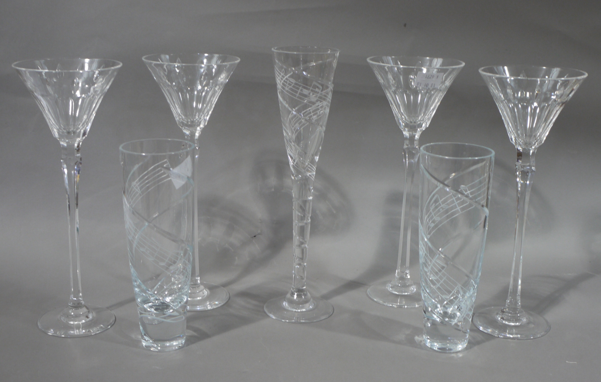 A set of four large wine glasses having slice cut conical bowls on faceted stems, 29.