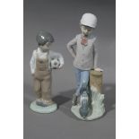 Two Nao figures of boy and dog beside a tree trunk,