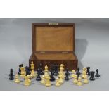 A Staunton style treen chess set of natural and ebonised colour in a mahogany box