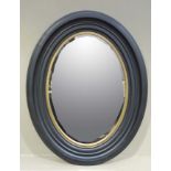 A reproduction wall mirror with black frame and gilt slip, bevelled glass,