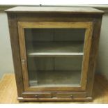A small glazed cupboard the door above a pair of small drawers, turned compressed bun feet,