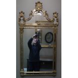 A reproduction giltwood mirror in ornate Italian style with shell cresting to the arched top,