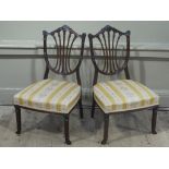 A pair of Edwardian nursing chairs having a pierced shield back,