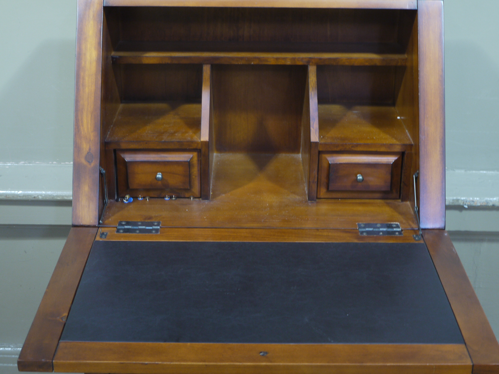 A modern bureau having fall front over triple fronted drawer and two door cupboard
