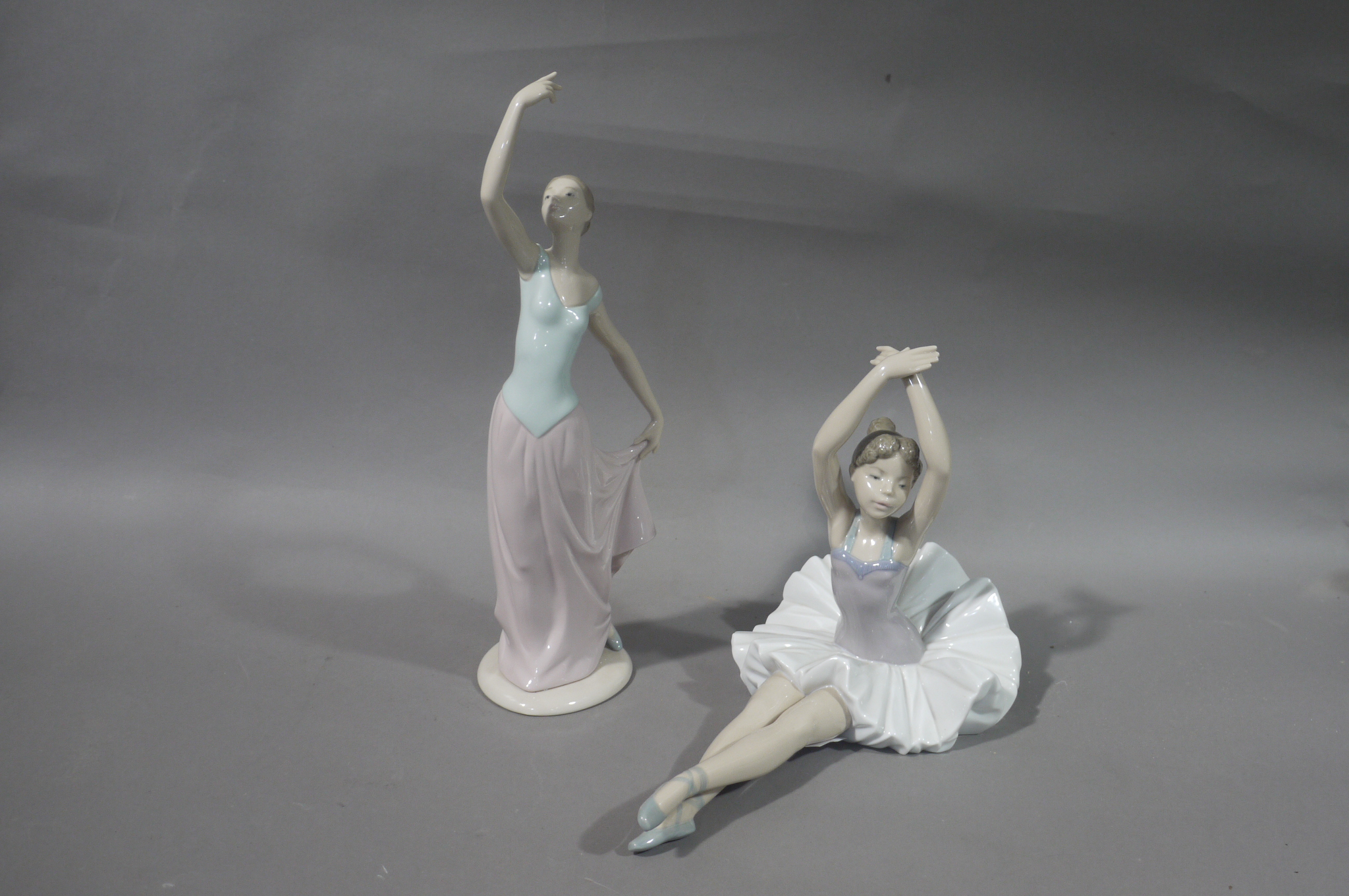 A Nao porcelain ballerina figure, 29cm wide; a Nao figure of young woman her arm aloft,