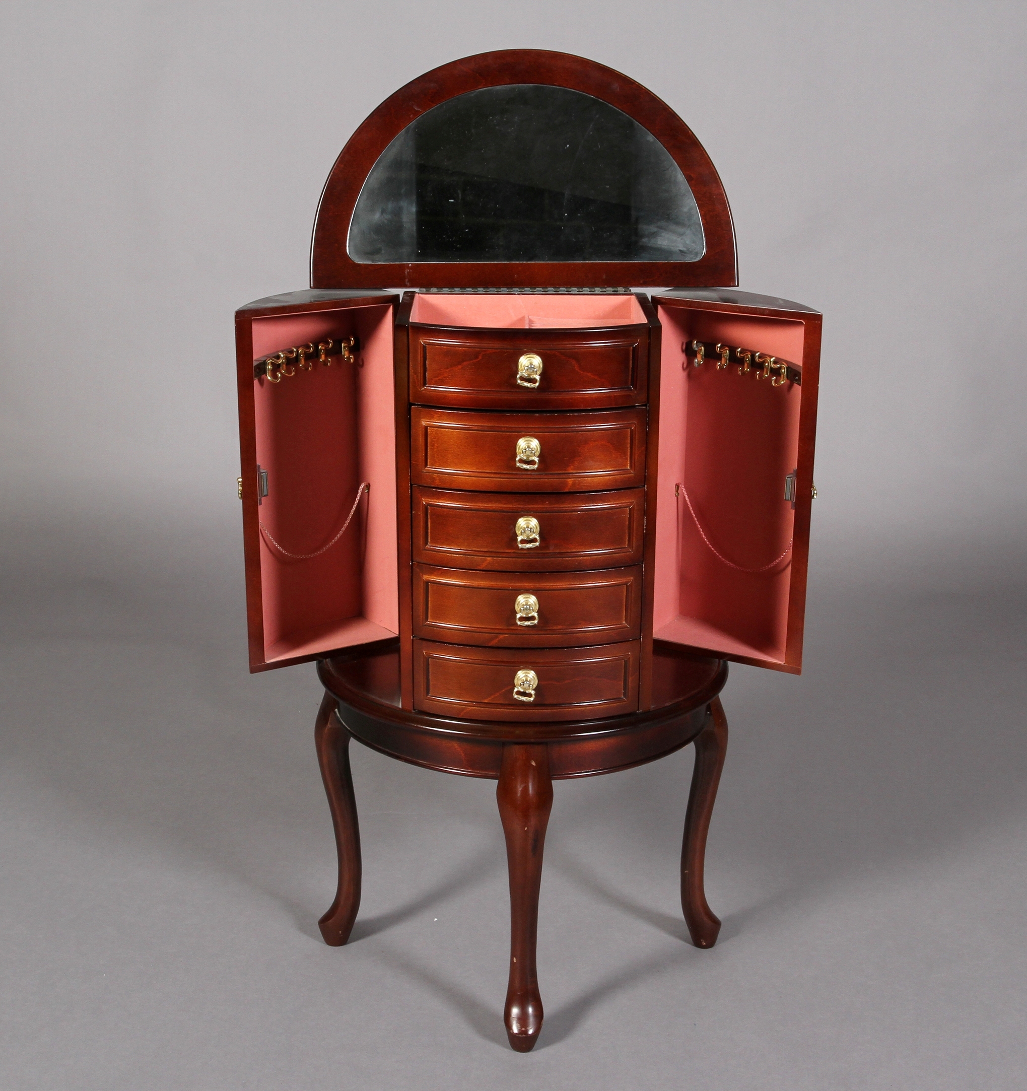 A mahogany finish D-shape jewellery cabinet having a lift up mirror lined top above an open