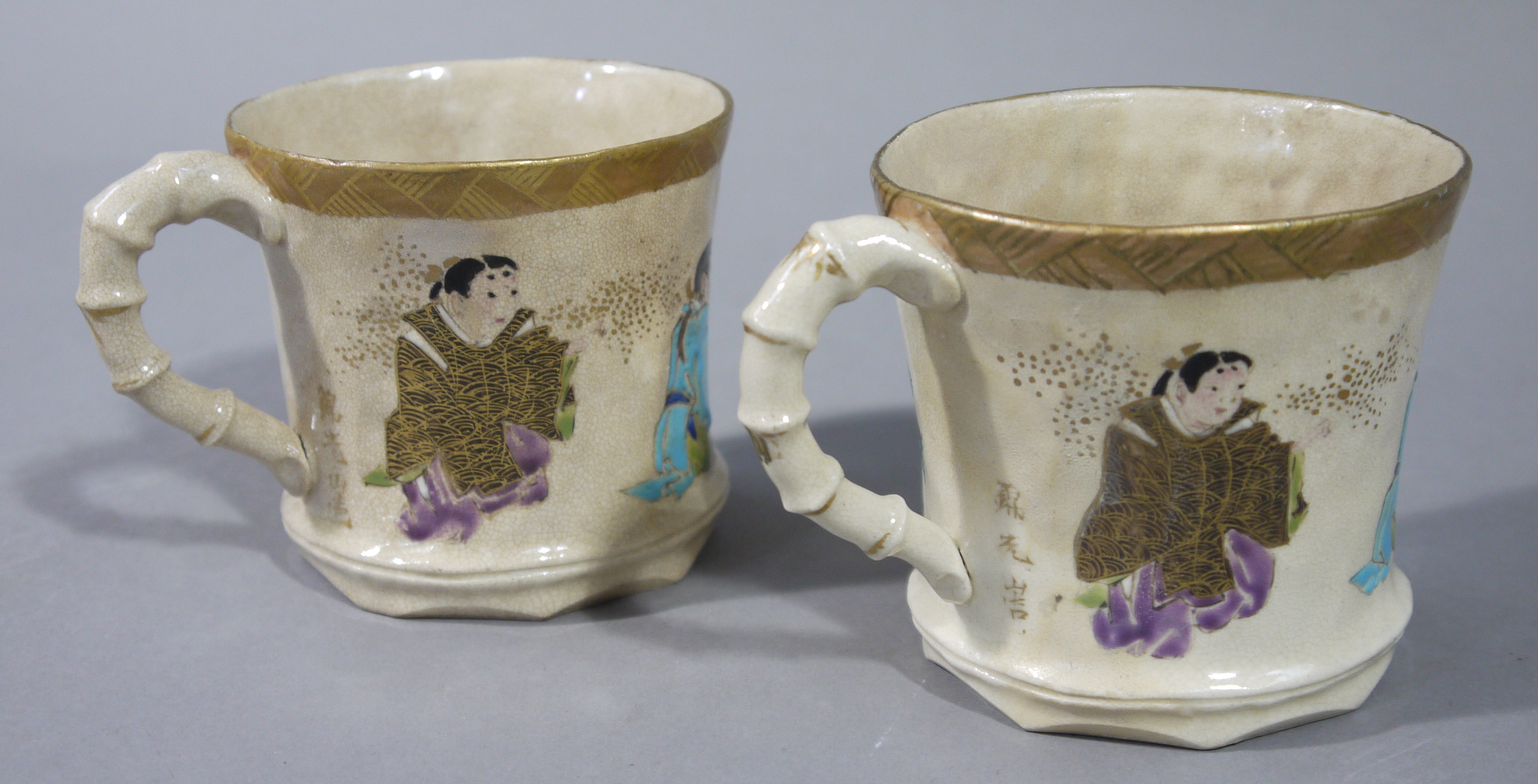 A pair of Japanese satsuma pottery waisted cylindrical mugs with faux bamboo moulded handles the