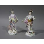 A pair of Sitzendorf porcelain figures, she with globe in her right hand and cornucopia on her hip,