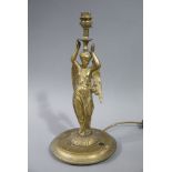 A Victorian gilt brass table lamp modelled as a winged lightly clad young woman on cast circular