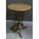 A pine tripod table, the circular top above a vasular turned column and three outswept legs,