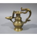 An Indian brass oil jug with stylised dragon cast handle the vasular body lobed with waisted neck,